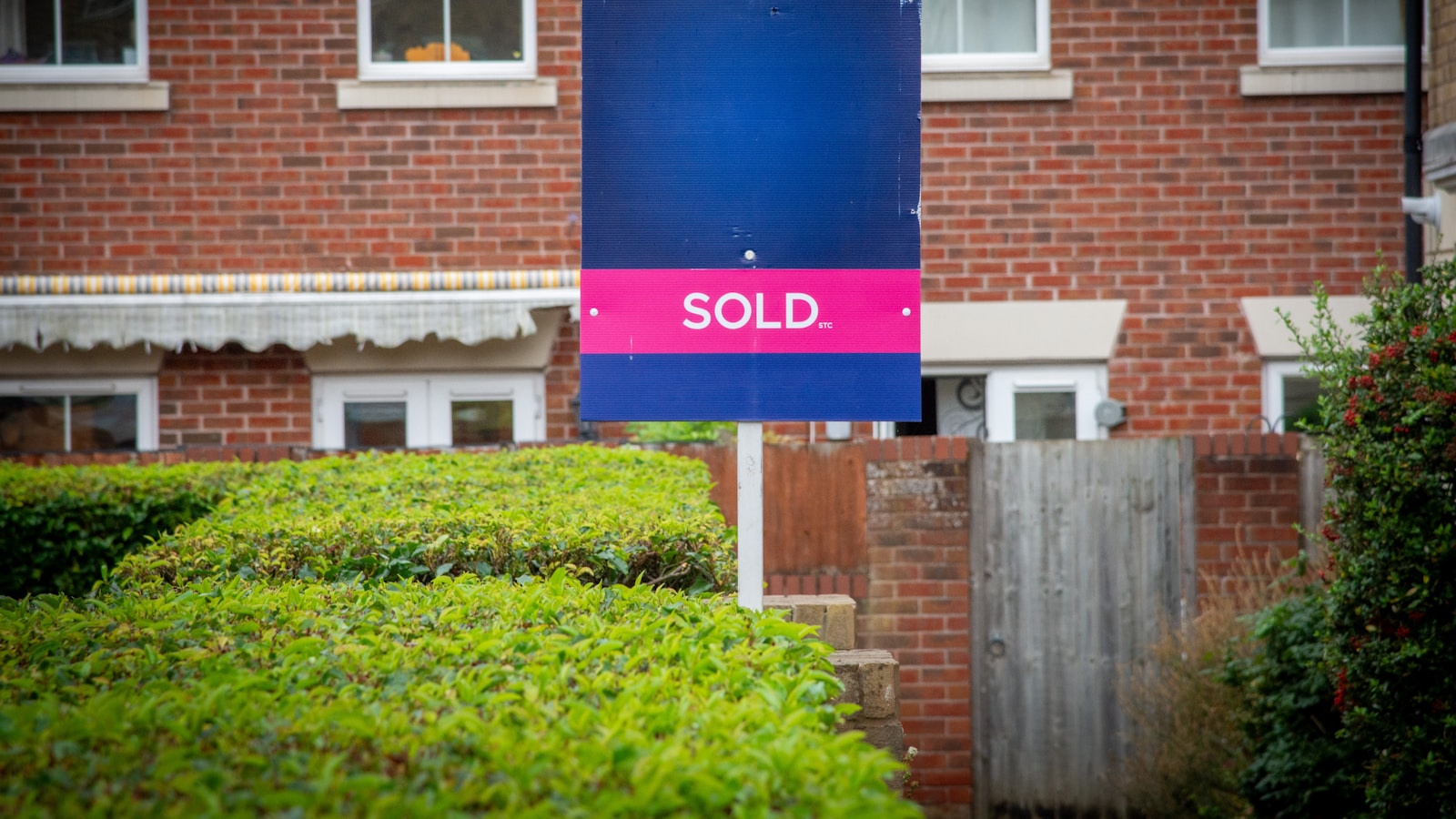 A sold sign in front of a brick building
