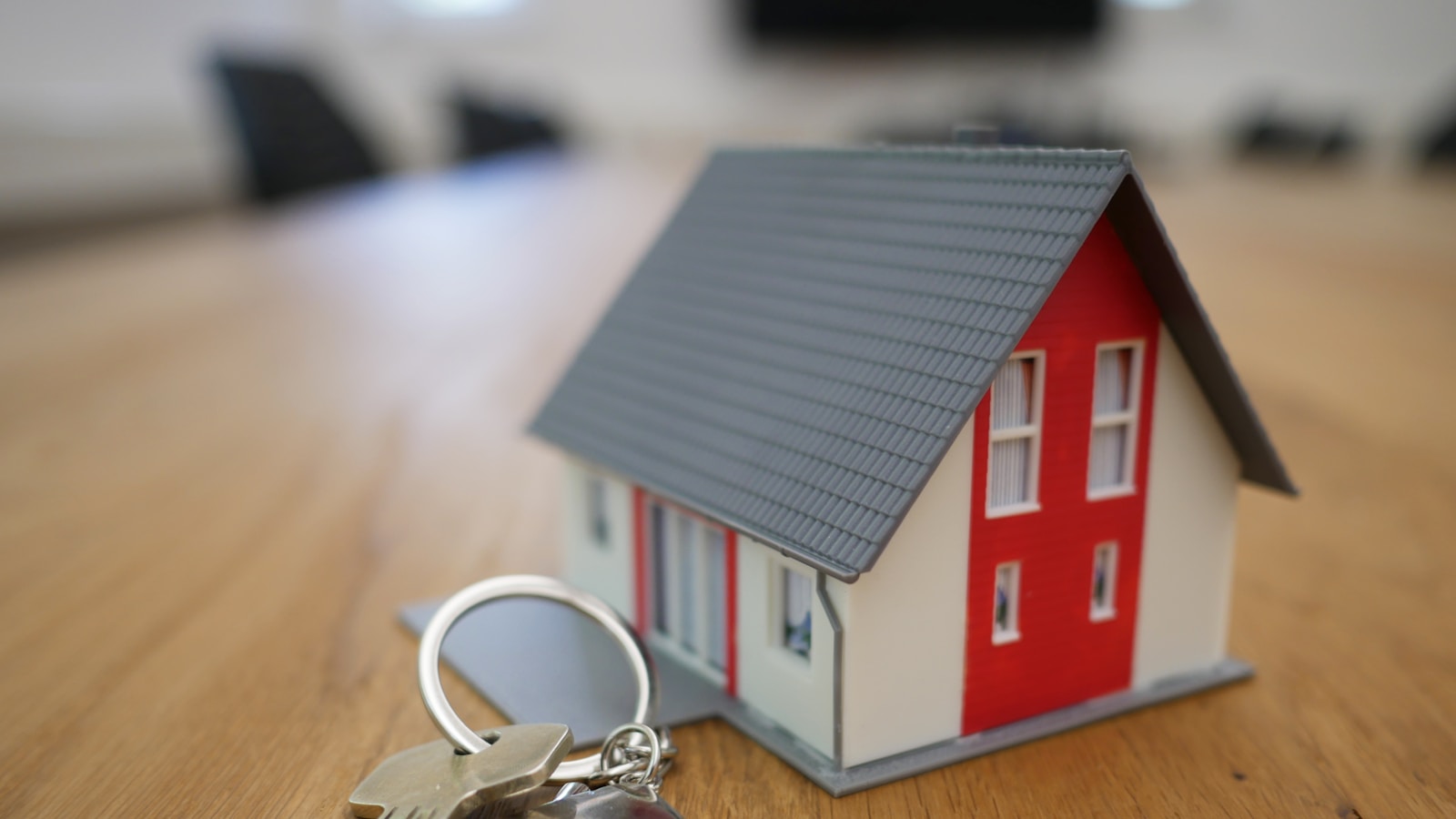 white and red wooden house miniature on brown table