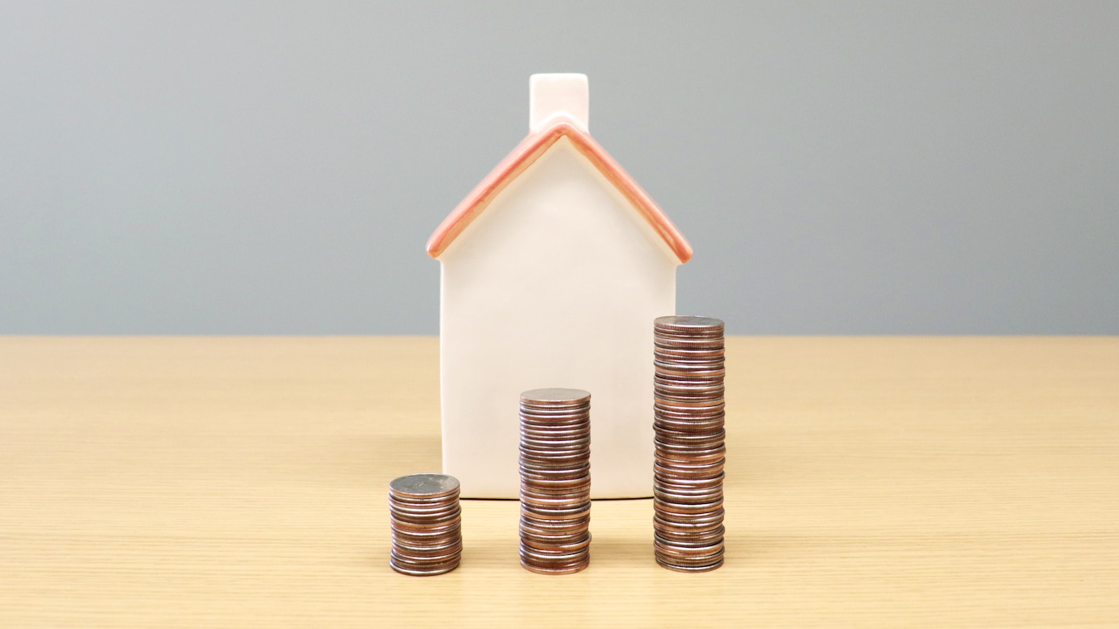 a house and stacks of coins on a table