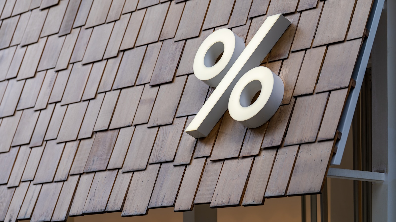 Large white percentage sign on wooden roof